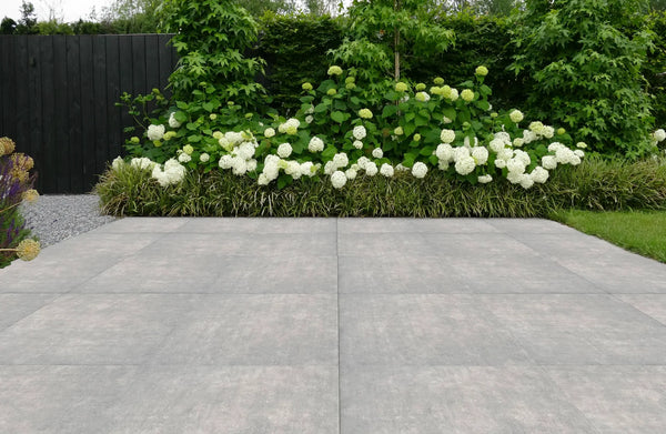 Blauwgrijs keramisch terras met een border met witte hortensia's